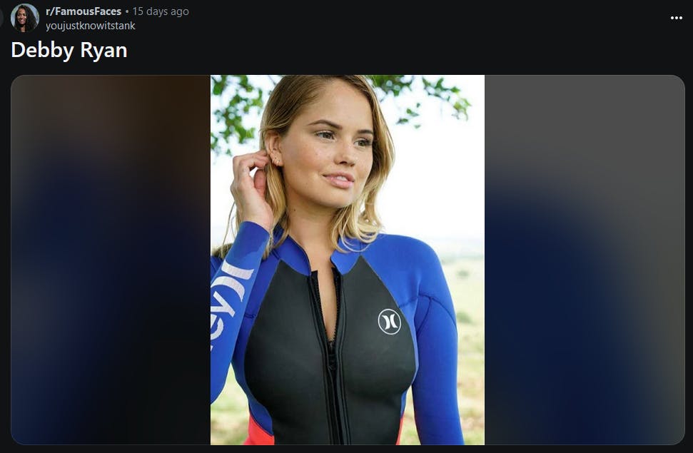 Debby Ryan in a wet suit doing the hair tuck and smirk from the meme.