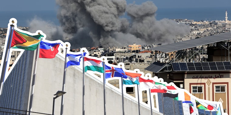 Smoke rises after Israeli air strikes near the border east of the city of Rafah in the southern Gaza Strip, on October 12 2023 behind UN flags