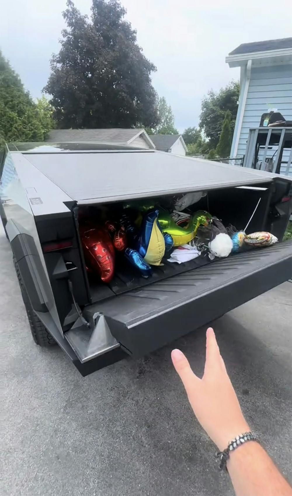 Hand pointing to tesla cybertruck trunk
