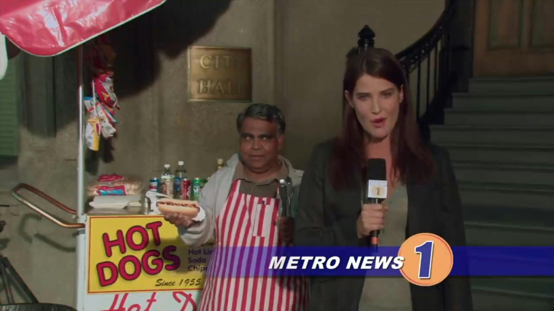 Robin reporting on Metro News 1 in front of a hot dog cart.