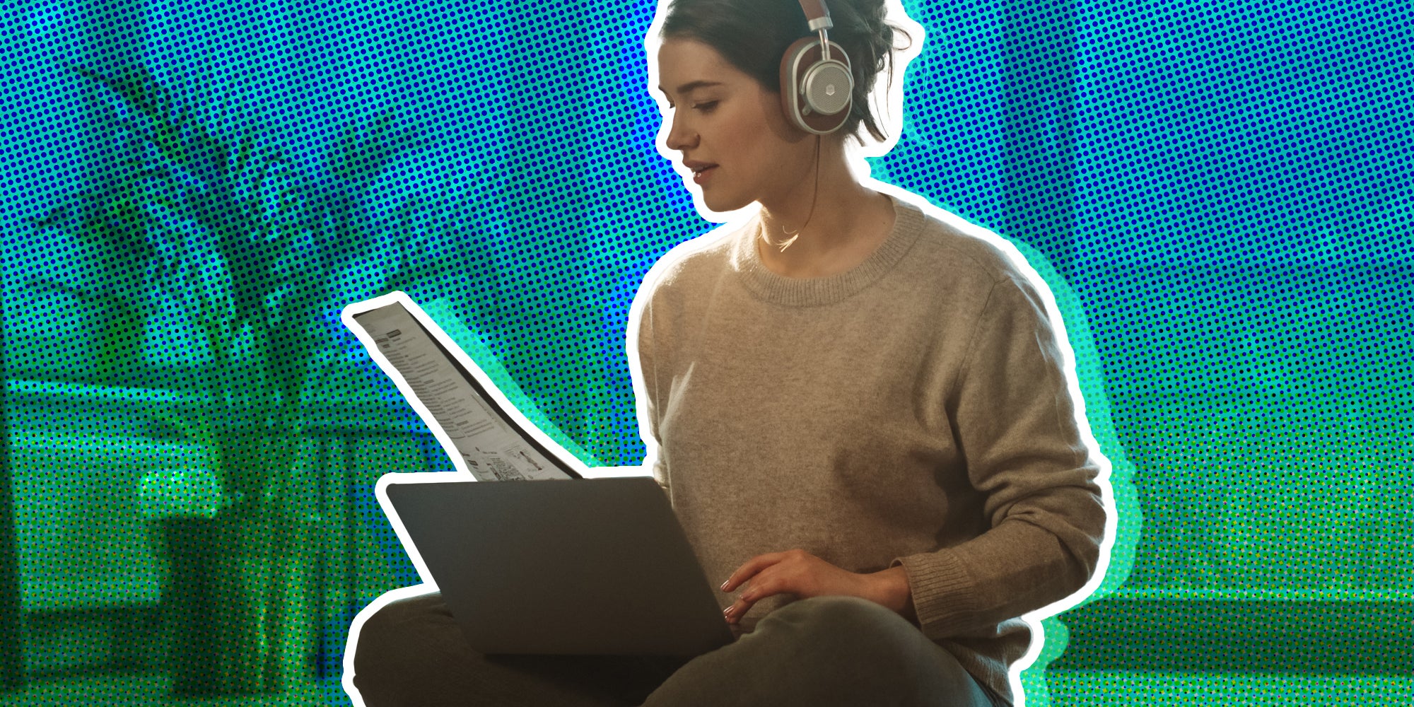 Woman at home on computer with magazine and headphones