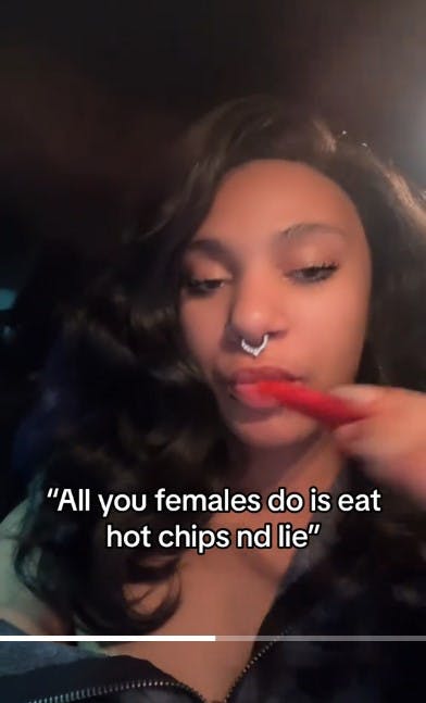 woman eats flamin hot cheeto with caption 'all you females do is eat hot chips and lie'