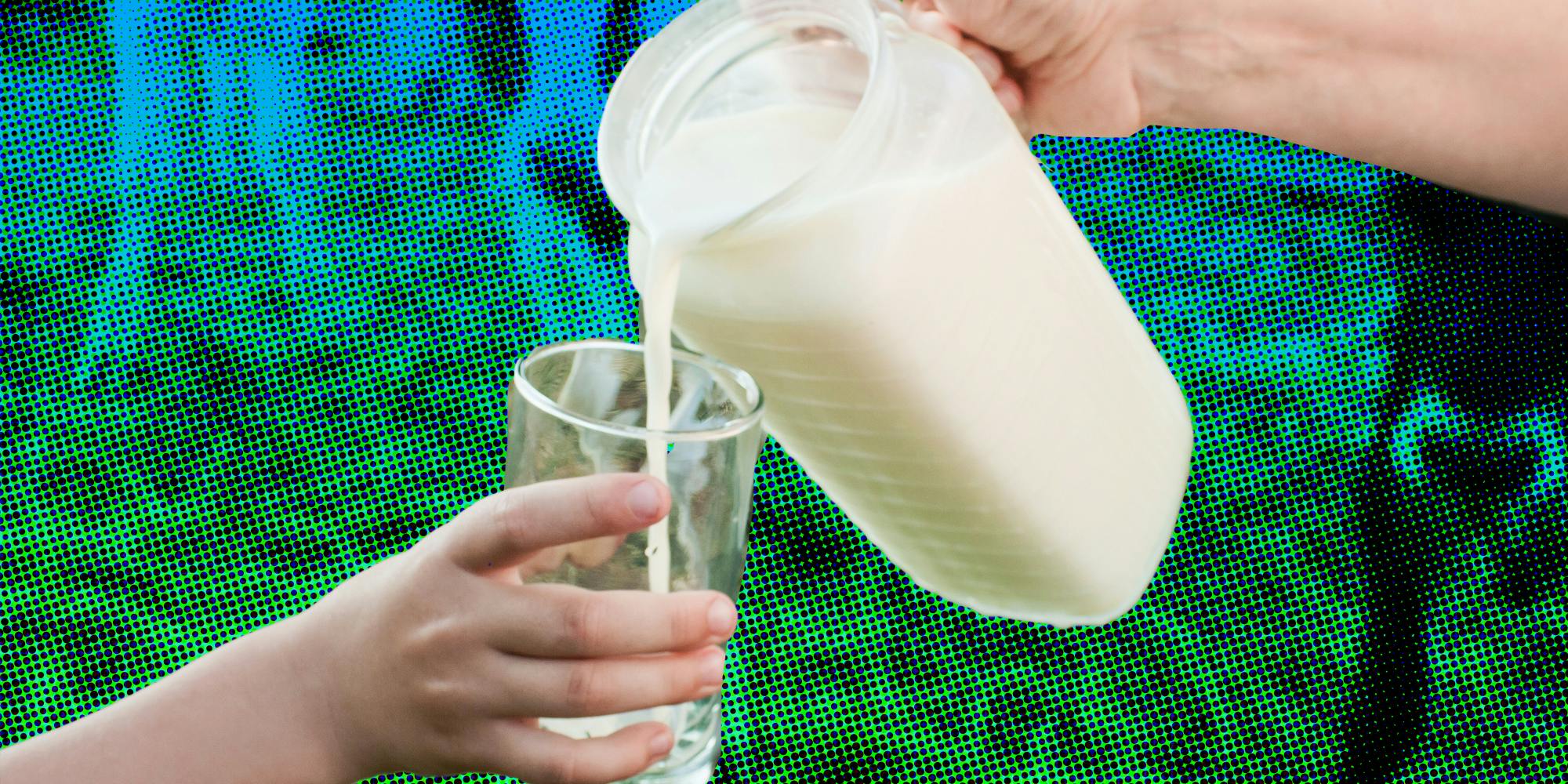 Hand pouring pitcher of milk into glass held by another hand