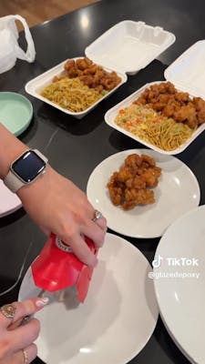 person scooping panda express from box onto plates