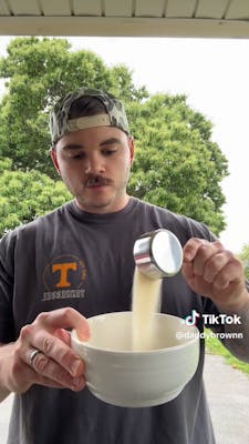 man pouring powder into bowl from measuring cup