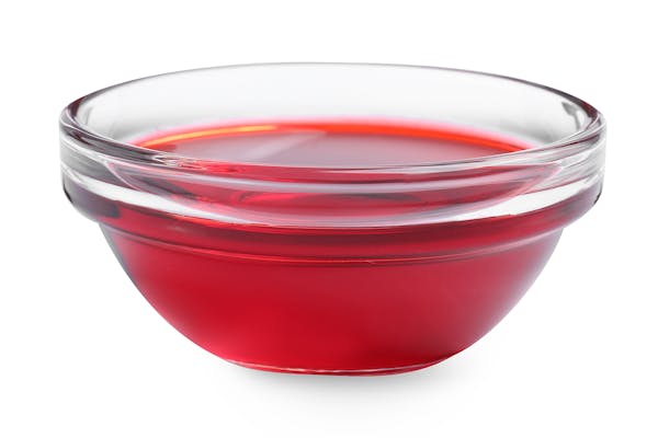 Glass bowl with red food coloring isolated on white