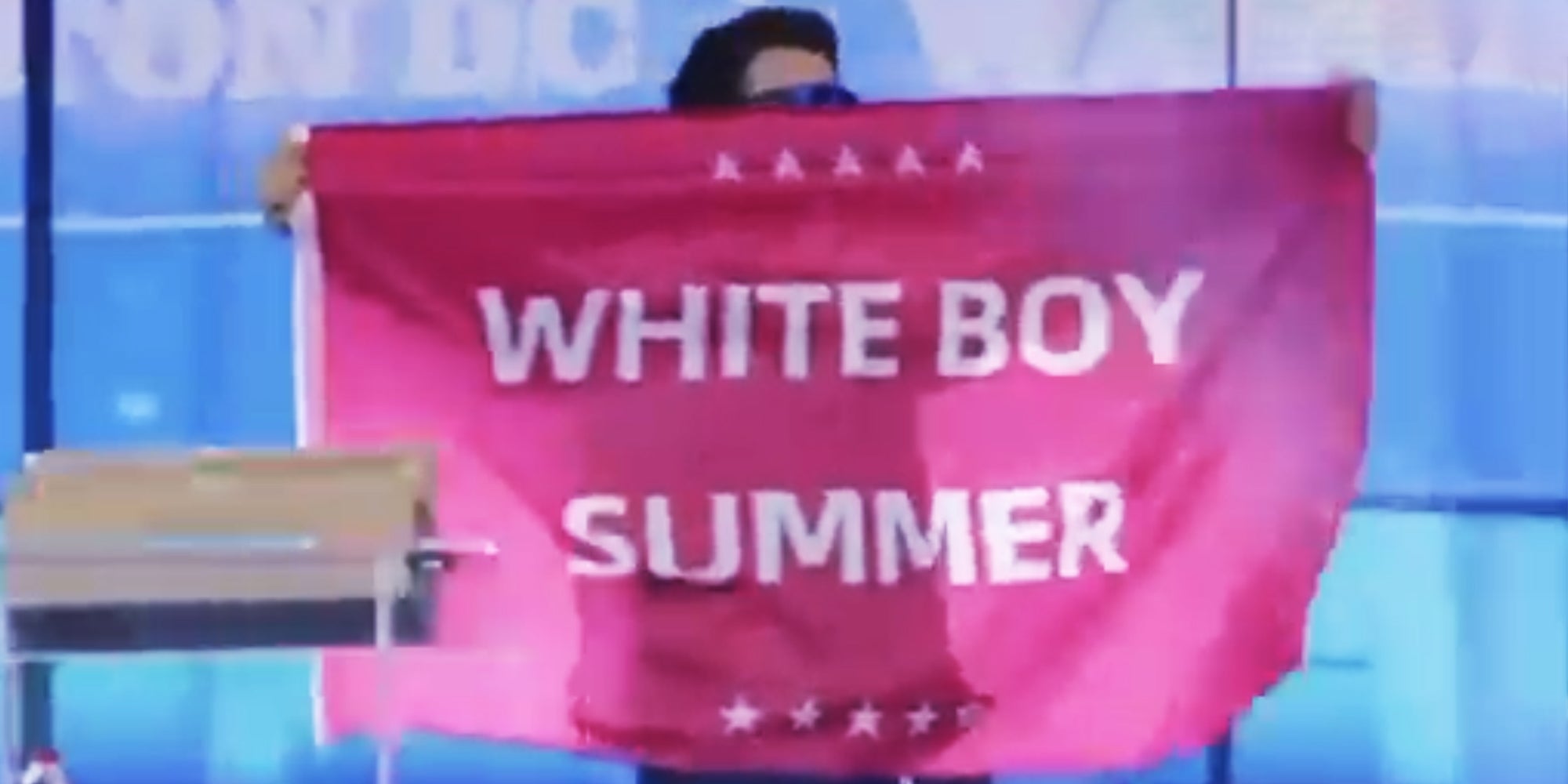 Man holding flag that says "White Boy Summer"