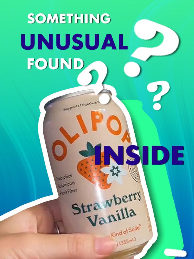 can in hand over green and blue