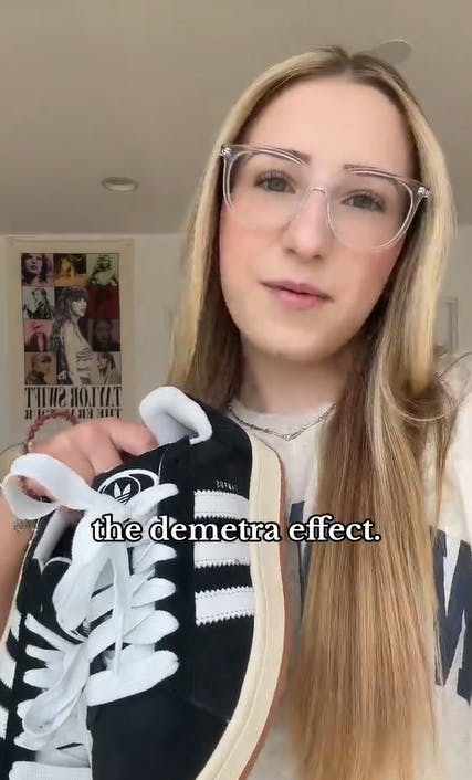 A young blonde woman in big glasses showing off a pair of Adidas in her hand. Text overlay reads, 'the demetra effect.'