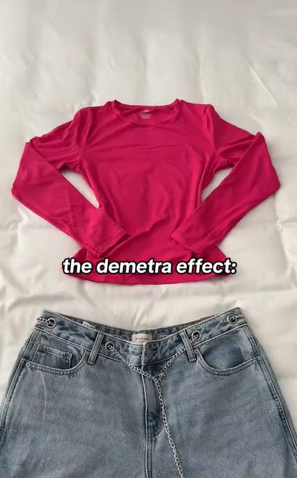 A longsleeve pink t-shirt and baggy jeans laid out neatly on a white comforter. Text overlay reads, 'the demetra effect:'