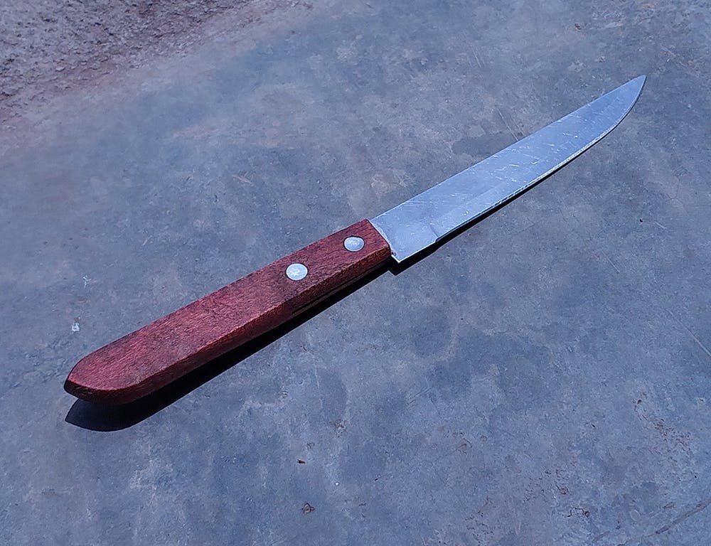 A sharp knife lay on the paved floor.