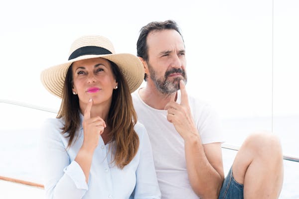Middle age couple traveling on sailboat serious face thinking about question, very confused idea