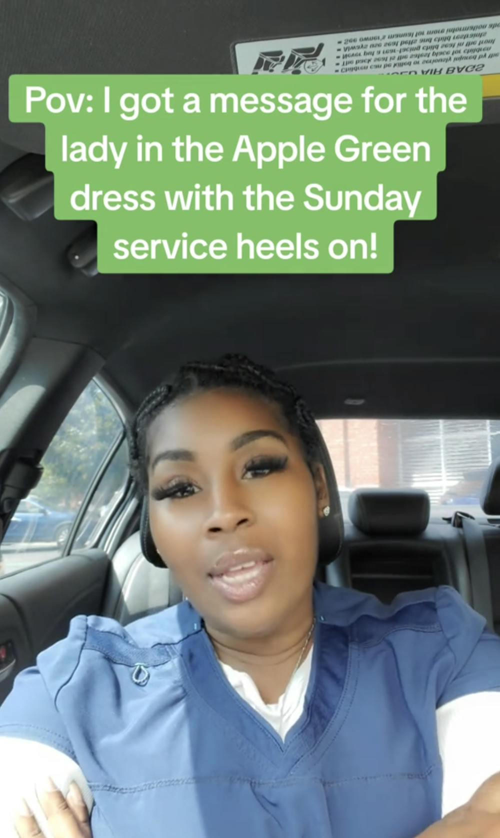 Screenshot of a Black woman in scrubs sitting in her car looking at the camera with her arms crossed. Text overlay reads, 'Pov: I got a message for the lady in the Apple Green dress with the Sunday service heels on!'