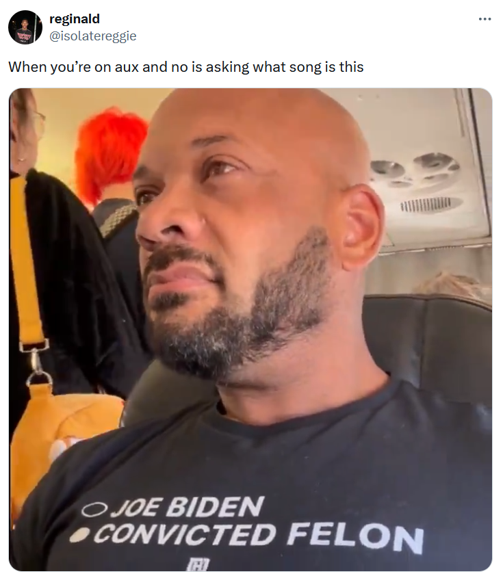 Guy in plane wearing convicted felon shirt meme about being on the aux.