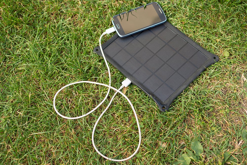 Use of renewable energy - Mobile Phone Chargers on grass in nature with Sun