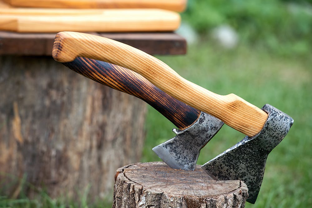 Outdoors displays handcrafted wood and metal crafts, natural wood cutting boards and axes