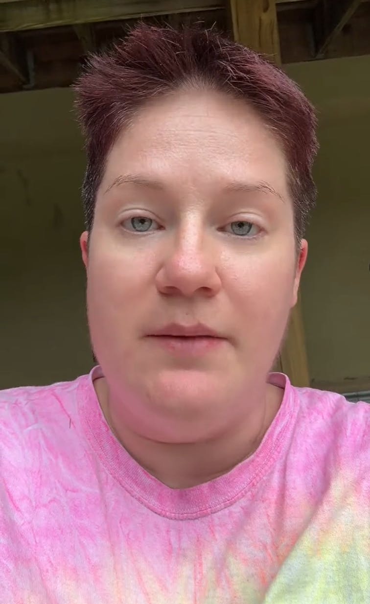 Short haired woman in a tie-dyed shirt looking at the camera.