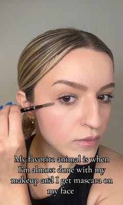 A blonde woman putting on her makeup. Text overlay reads, “My favorite animal is me when I’m almost done with my makeup and I get mascara on my face.”