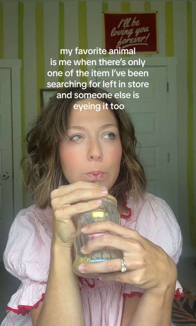 A woman in a nightie sipping on a drink in a mason jar, looking off into the distance. Text overlay reads, 'My favorite animal is me when there’s only one of the item I’ve been searching for left in the store and someone else is eyeing it too.'