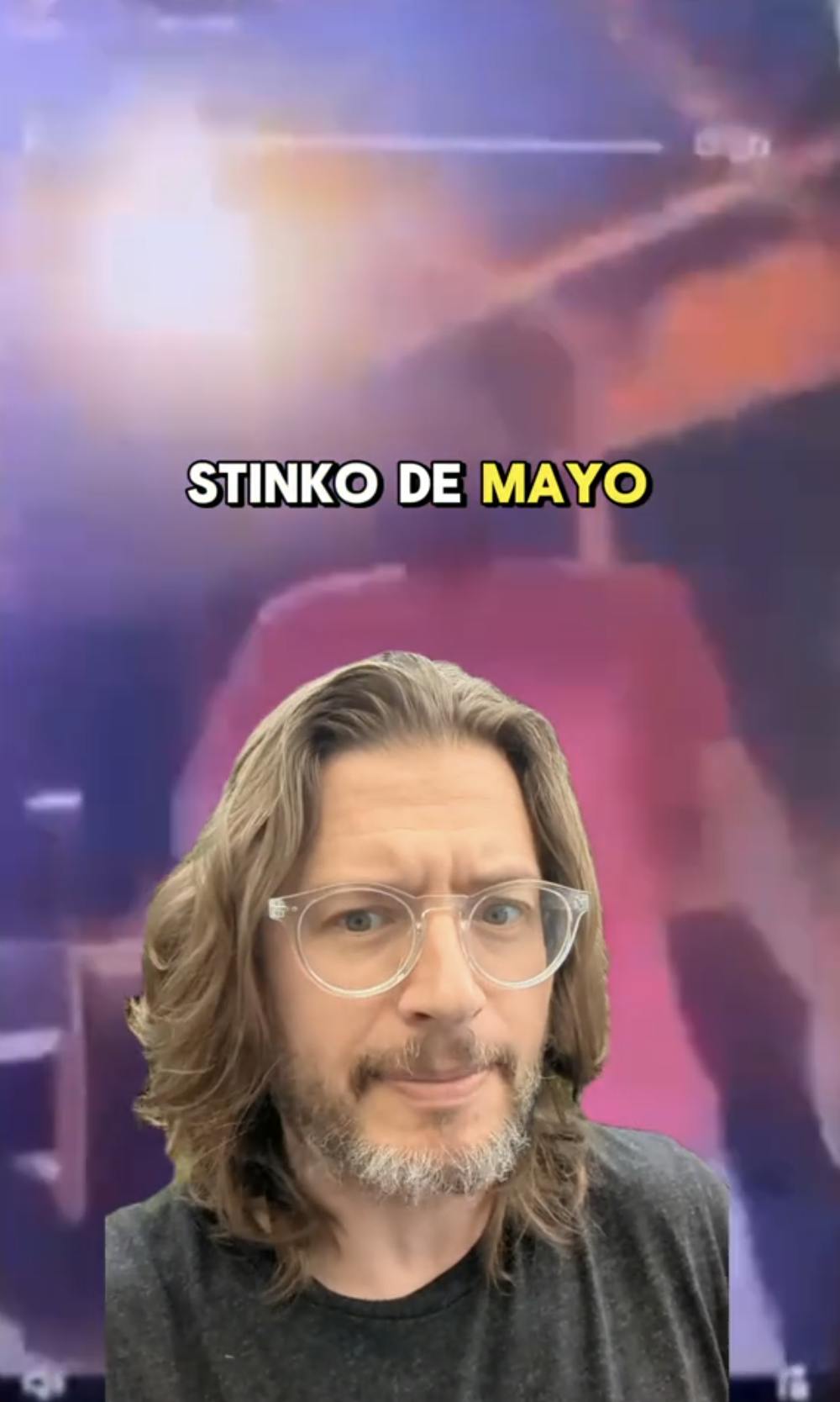 Screenshot of a TikTok video with a blurry greenscreened video background. The man in front of the video looks bemused and the text, 'Stinko de Mayo' is in the overlay.