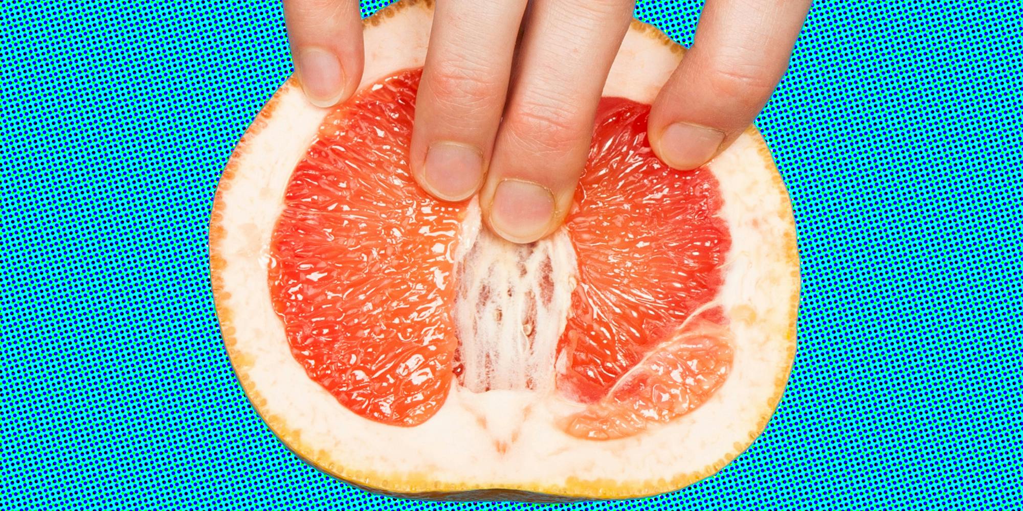 Hand touching grapefruit on blue background