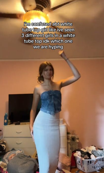 Screenshot of a woman dancing with text overlay that reads, 'i'm confused about white tube top girl like ive seen 3 different girls in a white tube top idk which one we are hyping.'