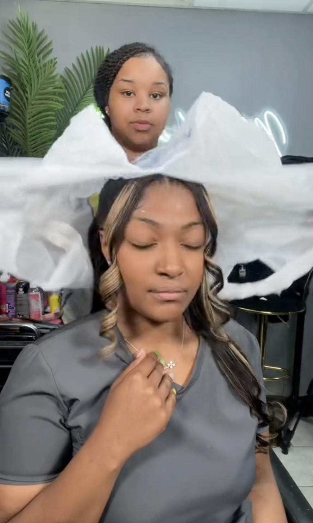 A hair stylist 'ripping' a plastic bag from around a client's head to reveal her new hairstyle.