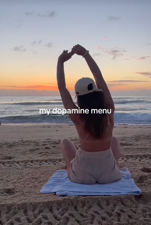 Dopamine menu TikTok video showing a woman stretching on a beach.