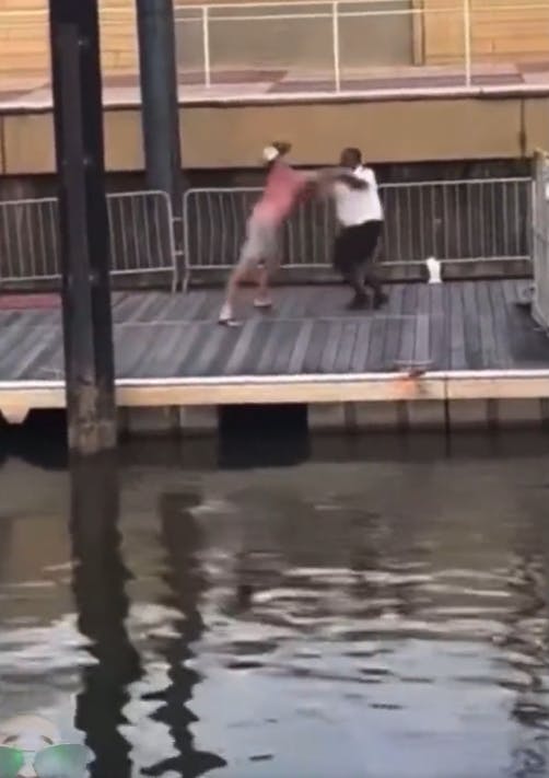 A white man punching a Black man on the docks at the Montgomery Riverside brawl.