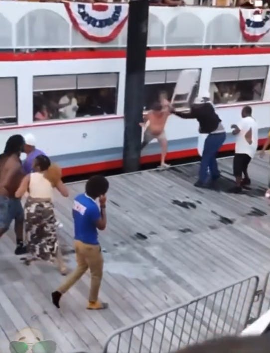 A Black man hitting a white man with a folding chair on the docks during the Montgomery Riverside brawl.