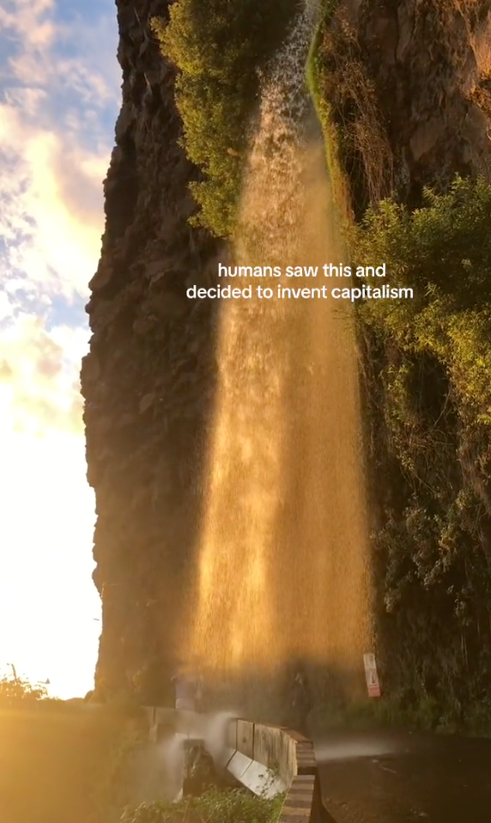 Humans Saw This meme of a waterfall at sunset over a hiking path.