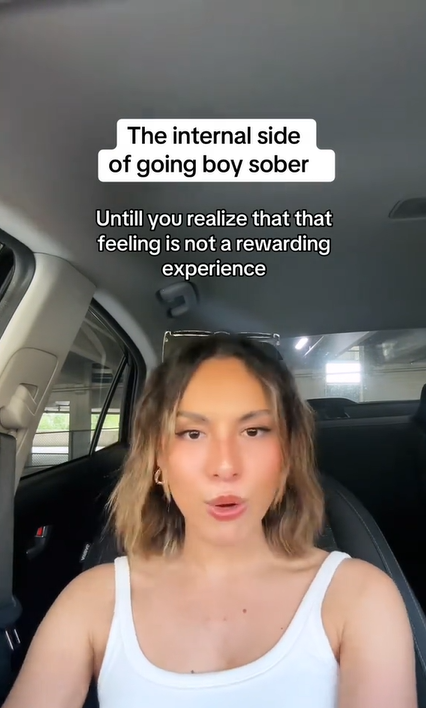 Woman sitting in her car. Text overlay reads, 'The internal side of going boy sober.' and 'Untill you realize that that feeling is not a rewarding experience'