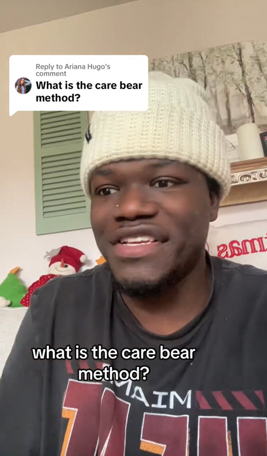 A man in a white beanie staring off to the side. He is replying to a TikTok comment that reads, 'What is the care bear method?'