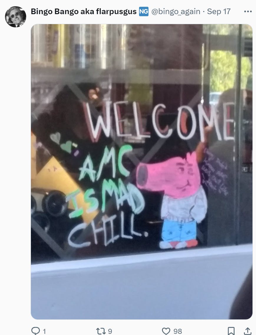 Photo of a storefront window drawing of the My New Character meme. Text on the window reads, 'WELCOME AMC IS MAD CHILL.'