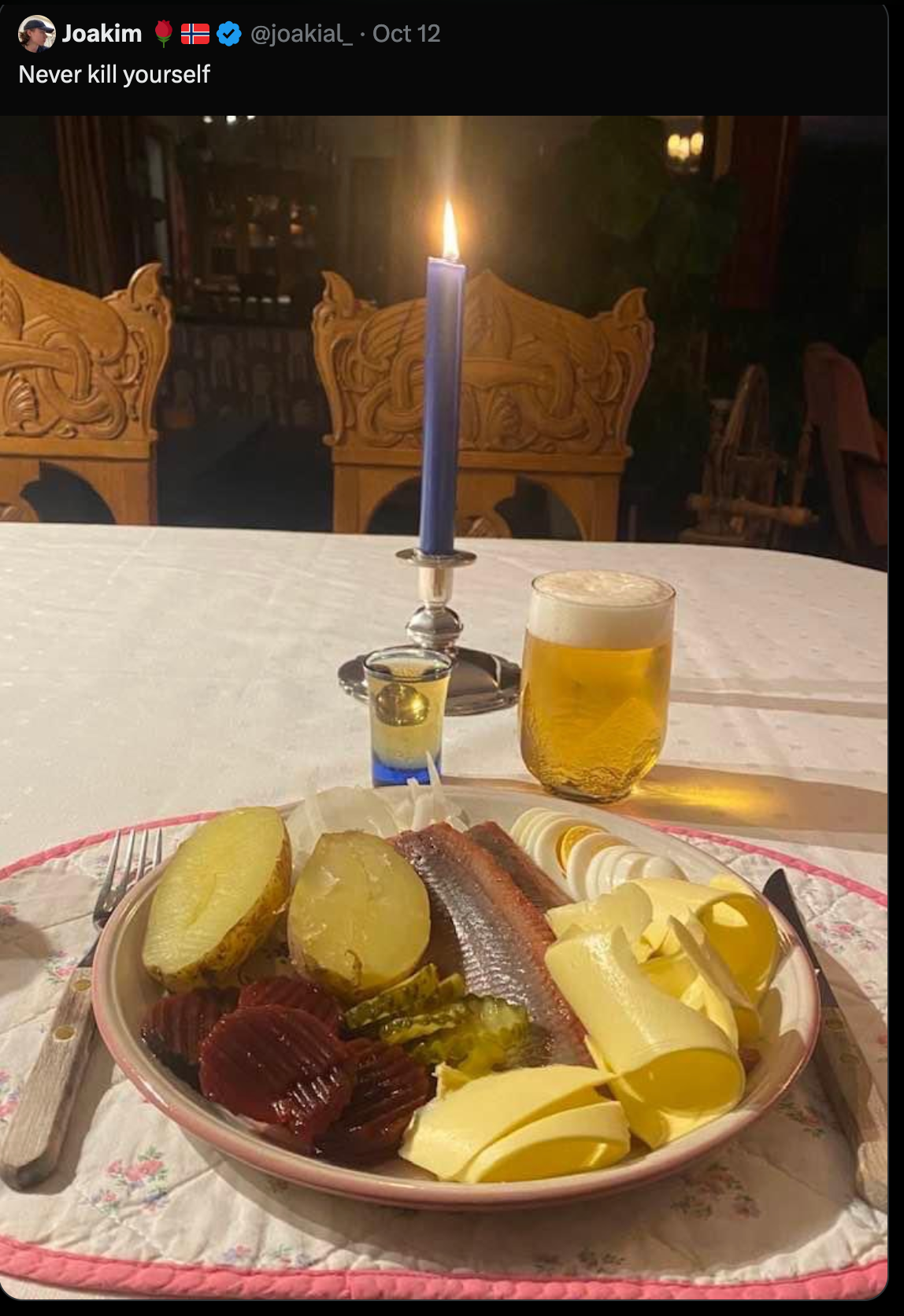 a X post depicting a candellit tabletop. On top of the taletop is a shot of whiskey, a large beer and a large plate of butter, fish, potatoes, pickes and beets (seemingly). The post is captioned 'Never Kill Yourself.'