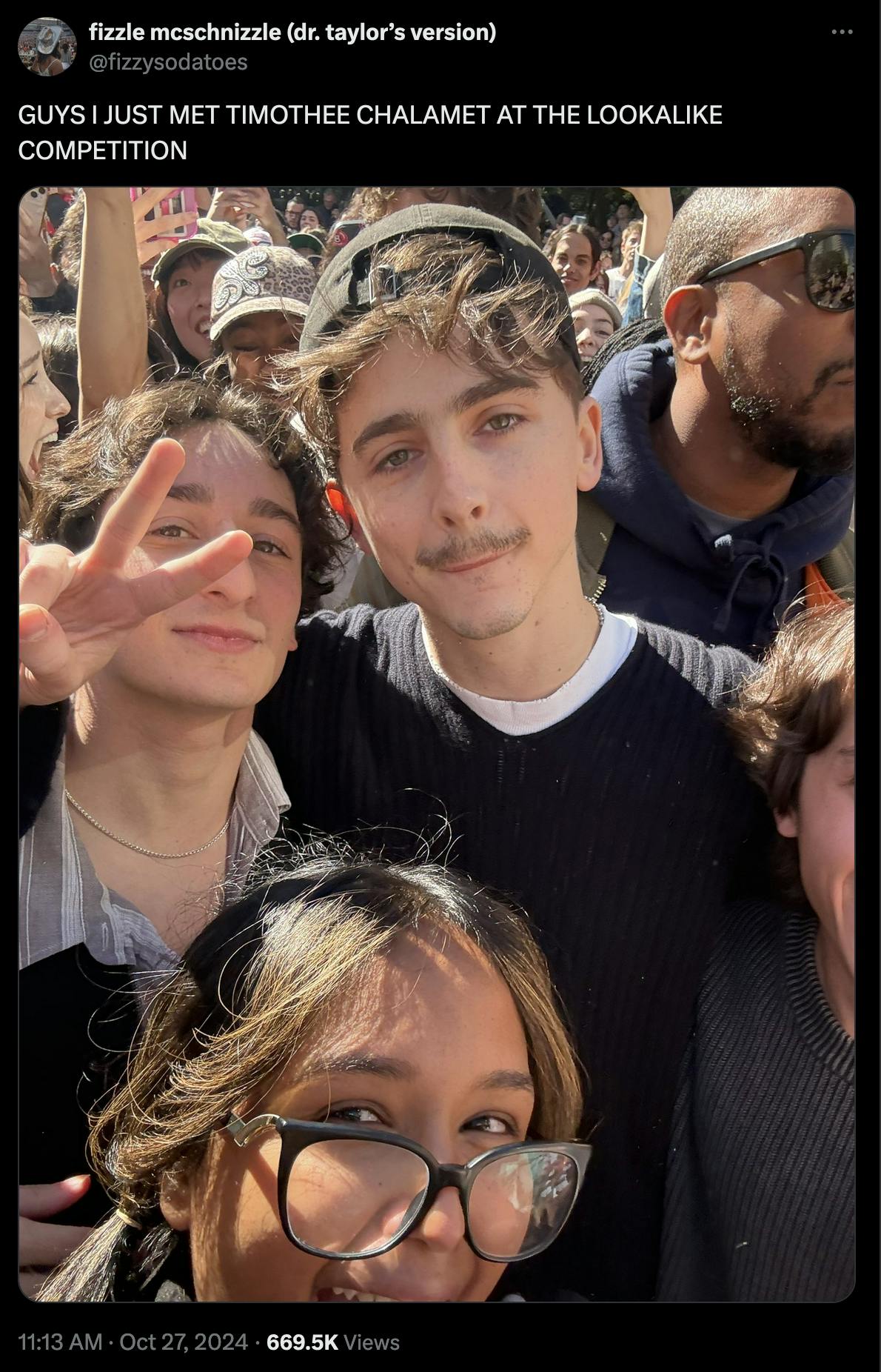 An X post of a user saying 'GUYS I JUST MET TIMOTHEE CHALAMET AT THE LOOKALIKE COMPETITION' and a photo of Timothee, a woman in glasses and a man who entered the contest (throwing up a peace sign).