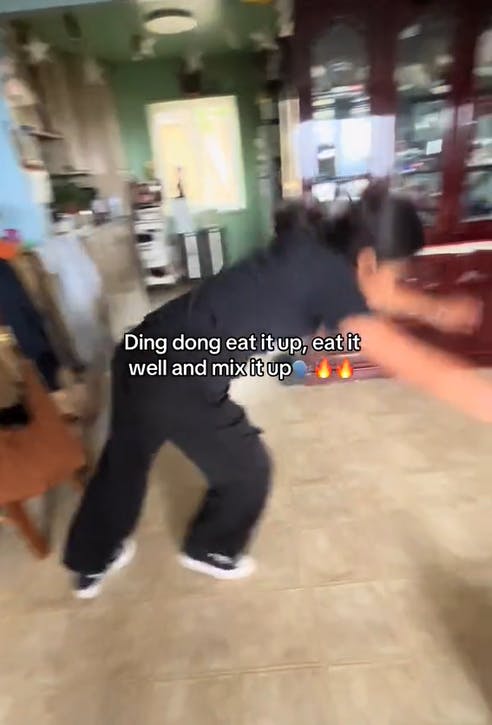 A young woman trying to do a cartwheel in her house.