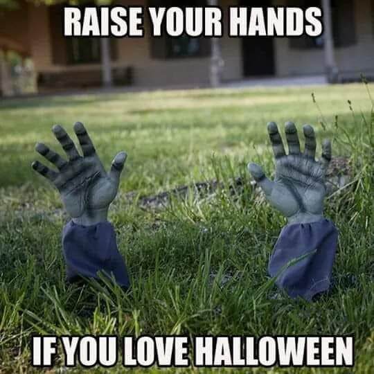 Halloween meme with zombie hands sticking out of grass. Text reads, 'Raise your hands if you love Halloween'