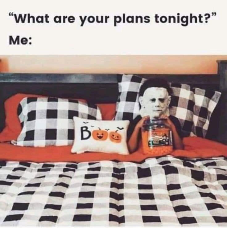 Text reads, 'What are your plans tonight? Me:' with a photo of a Halloween-themed bed and someone in a Michael Myers mask under the covers with candy.