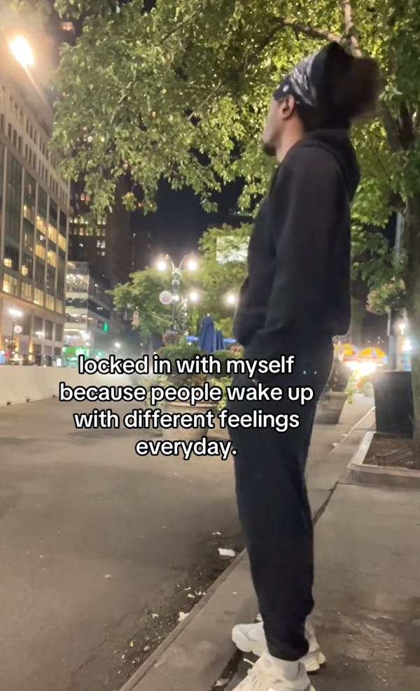 TikTok video showing a man in black looking out over a city street.