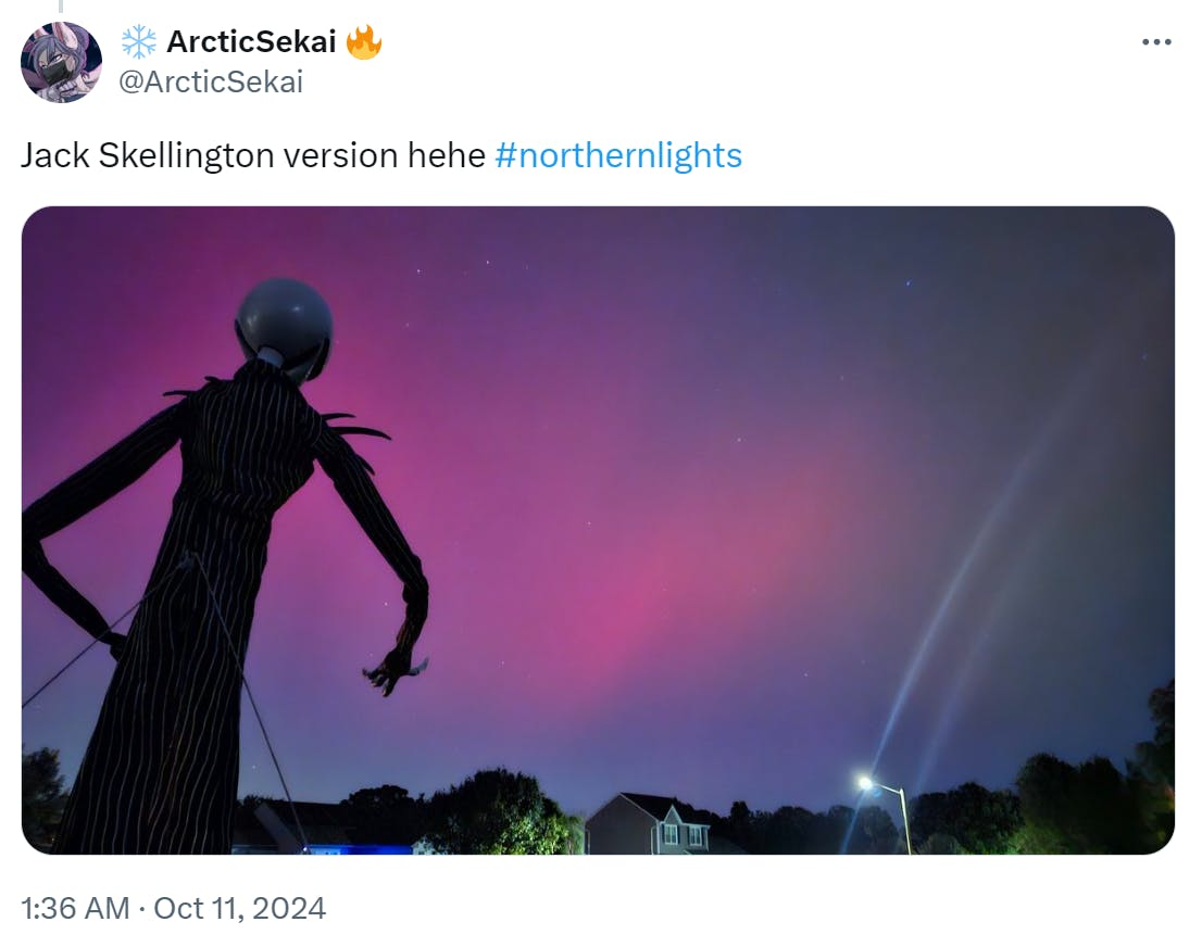 Photo of the northern lights with a Jack Skellington figurine looking at the sky.