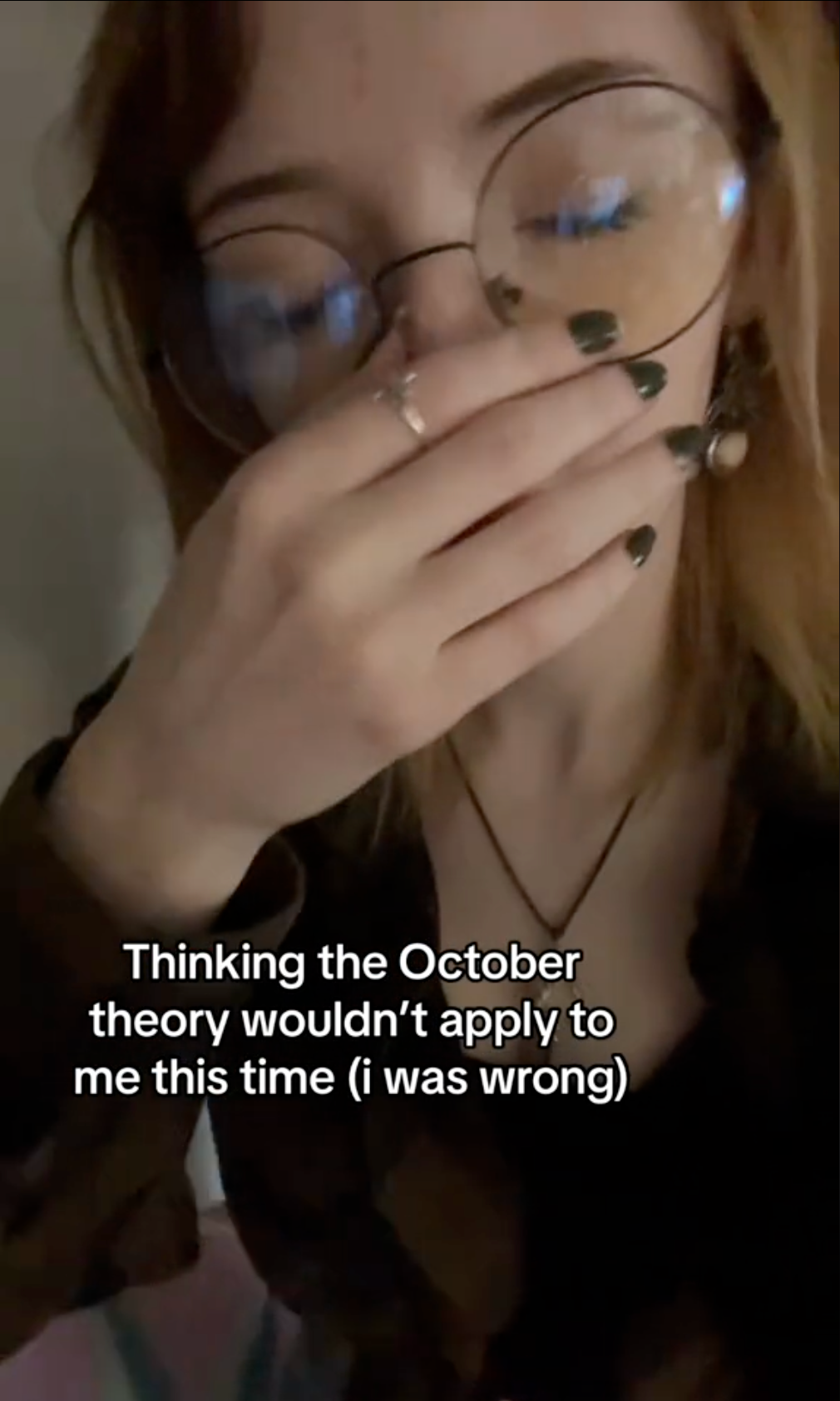 TikTok of a woman sighing and rubbing her nose in disbelief. Text overlay reads, 'Thinking the October theory wouldn't apply to me this time (i was wrong)'