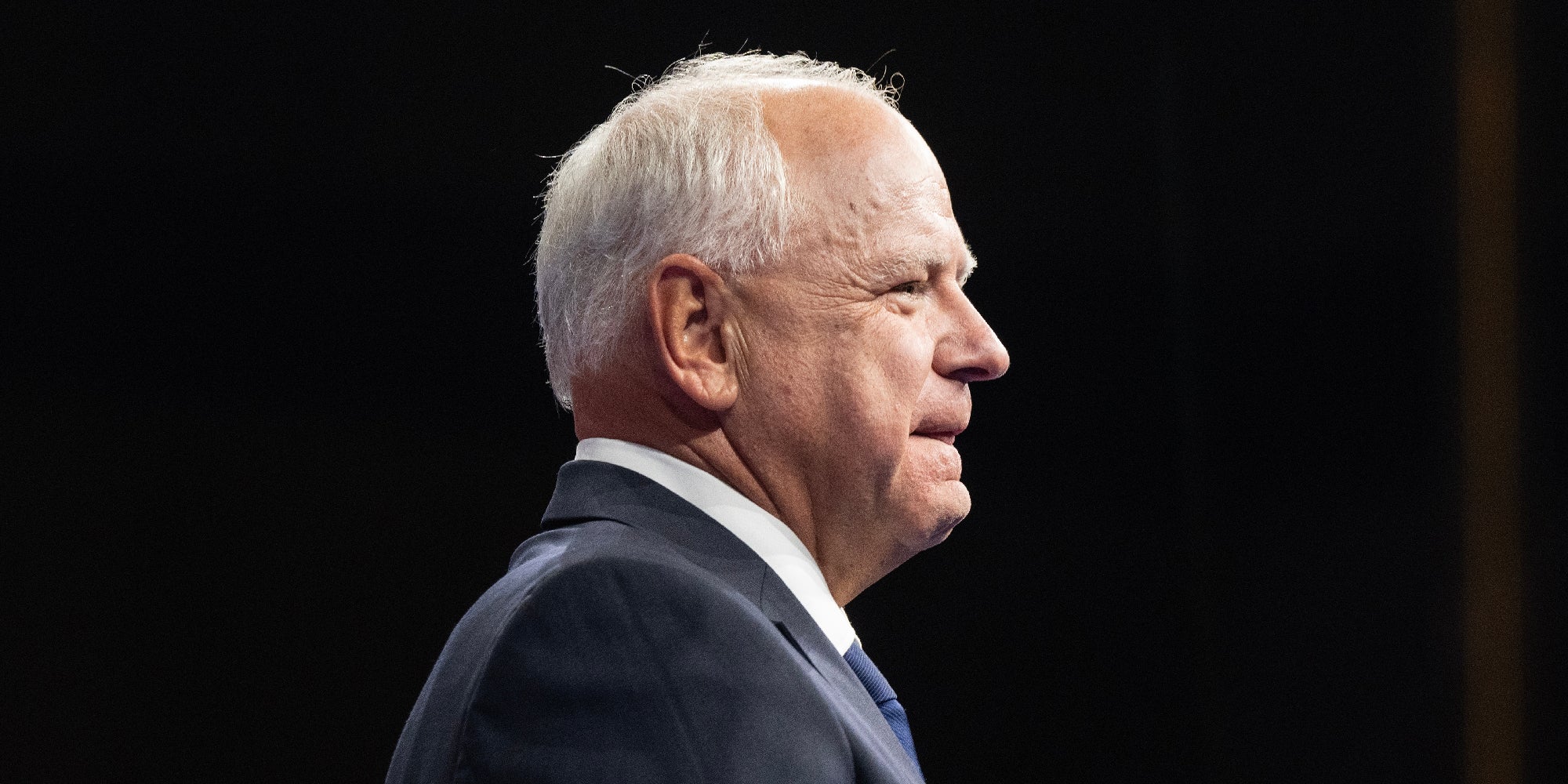 Tim Walz side profile against a black backdrop.