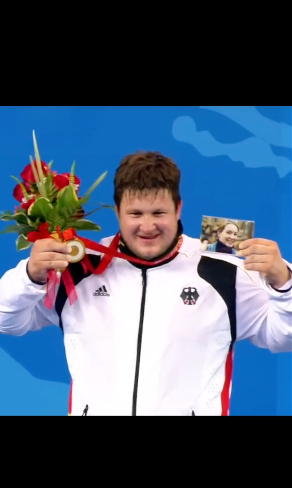 Hopecore TikTok of Olympic athlete Matthias Steiner holding up his late wife's photo with his medal.