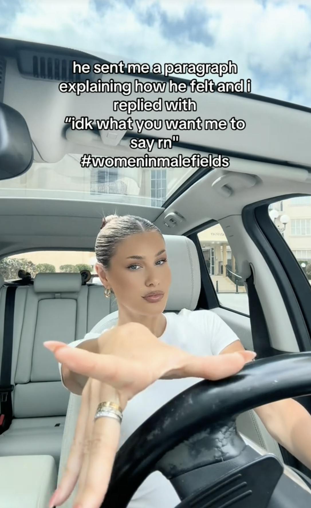 A TikTok video of a woman in her car, smiling at the camera, with the caption 'He sent me a paragraph explaining how I felt...etc. #Womeninmalefields'