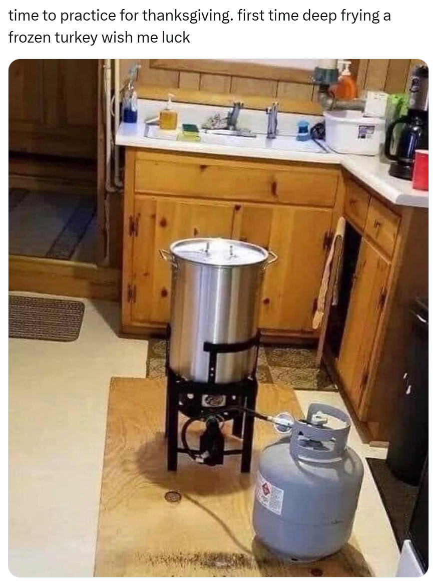 Funny Thanksgiving meme, text reads, 'time to practice for thanksgiving. first time deep frying a frozen turkey wish me luck' with a photo of a deep fryer and a propane tank inside a small kitchen.