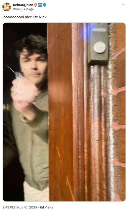 Photo of Nick Fuentes at his front door wielding pepper spray.