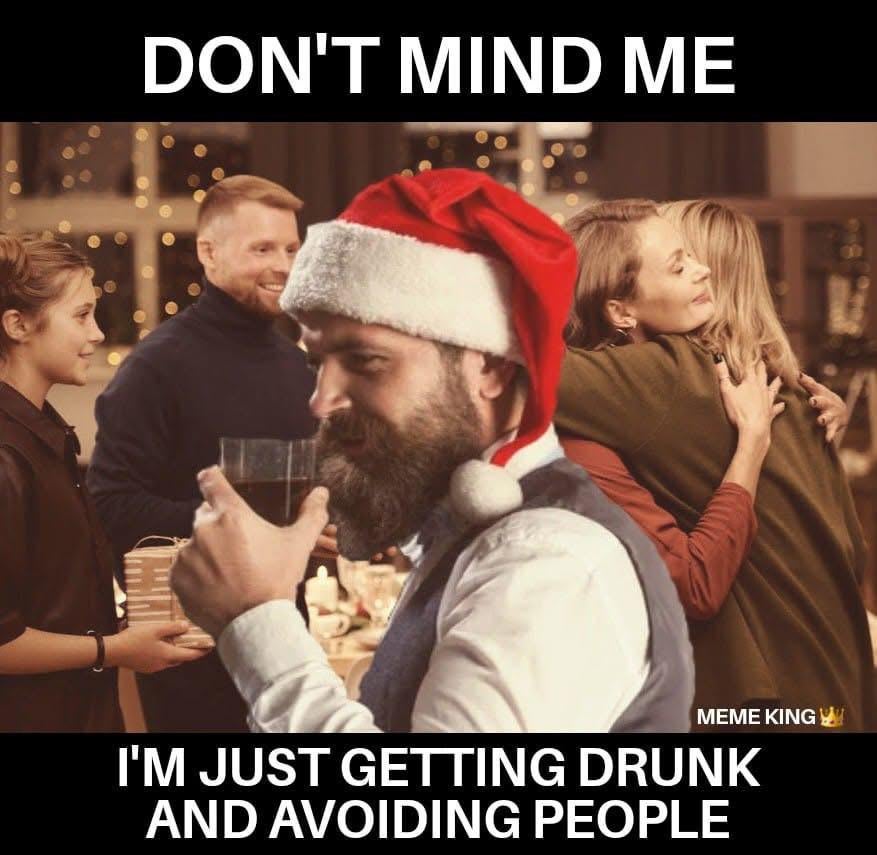 Introvert meme of a guy in a santa hat drinking at an event. Text reads, 'Don't mind me, I'm just getting drunk and avoiding people.'