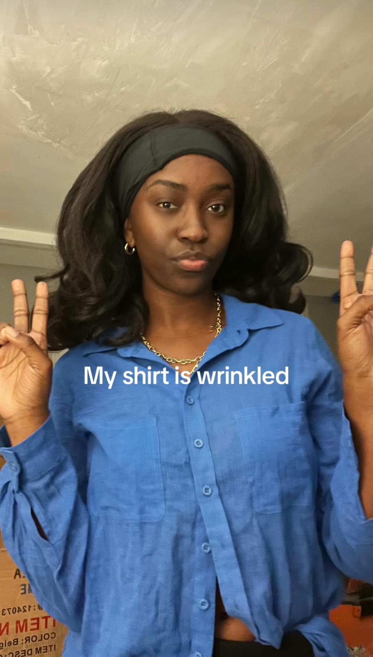 Photo of a woman a wrinkled blue button up shirt. Text overlay reads, 'My shirt is wrinkled.'