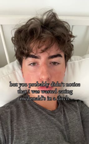 TikTok photo of a young man in bed staring blankly at the camera. Text overlay reads, 'but you probably didn't notice that i was wasted eating mcdonald's in a ditch.'